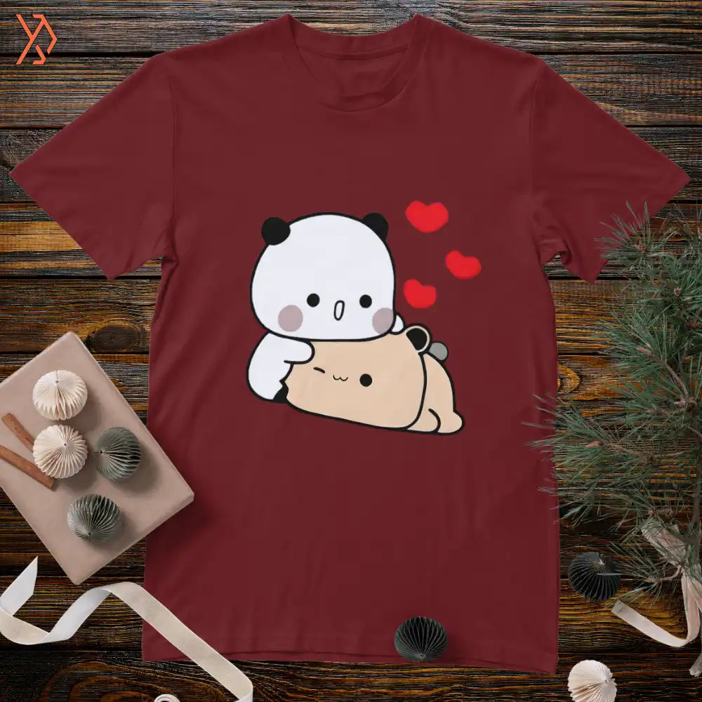 Maroon t-shirt with a cartoon panda and bear design on a wooden surface. yourdora.pk