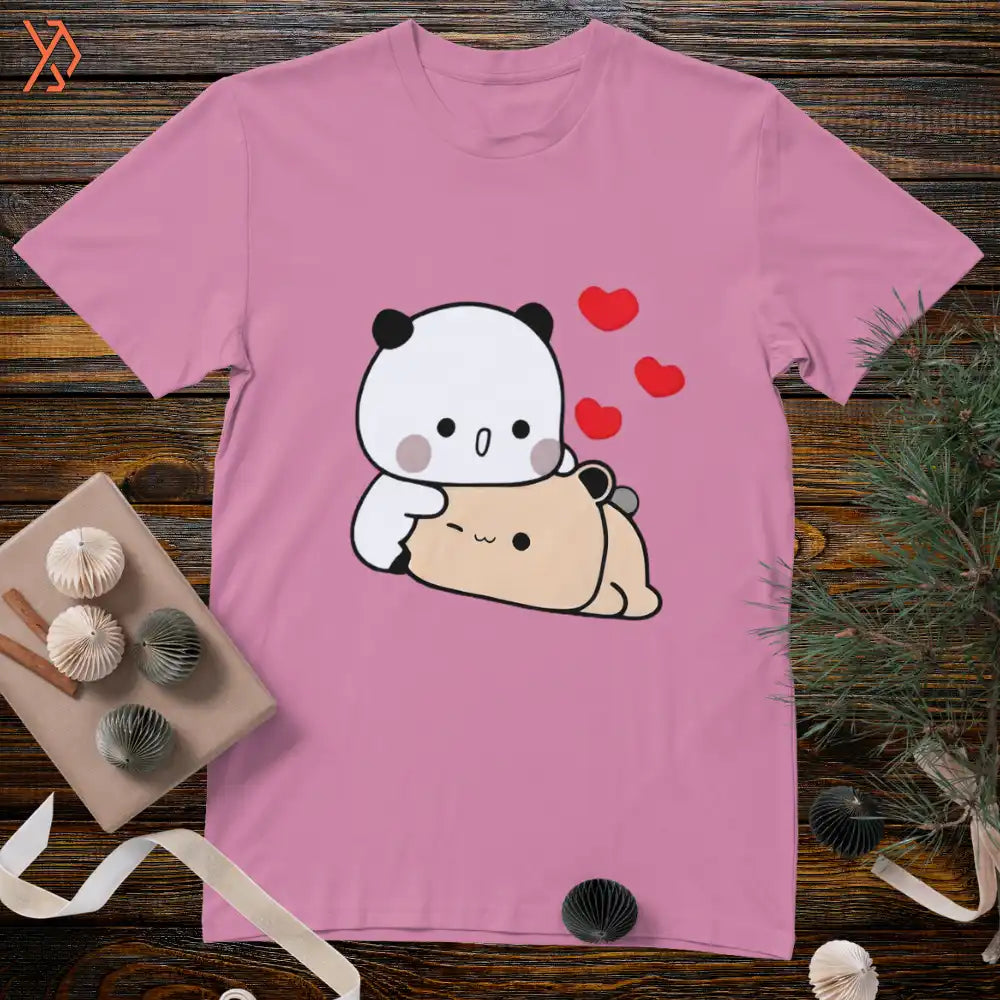Pink t-shirt with a cartoon panda and bear design on a wooden surface. yourdora.pk