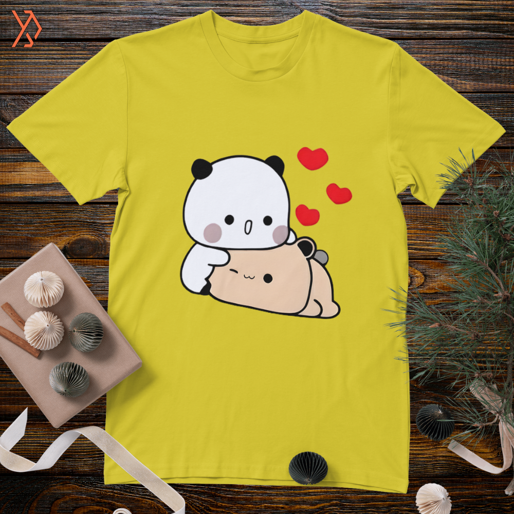 Yellow t-shirt with a cartoon panda and bear design on a wooden surface.