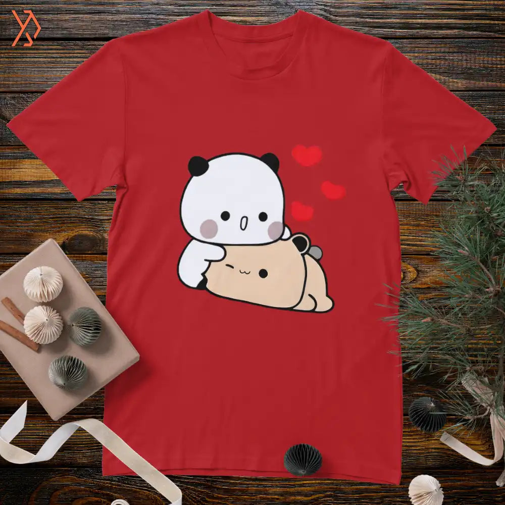 Red t-shirt with a cartoon panda and bear design on a wooden surface. yourdora.pk